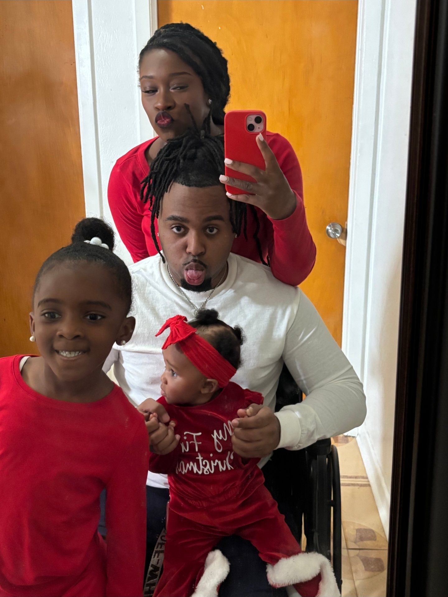 Dyimond's holiday mirror selfie with her two daughters and family, everyone in red