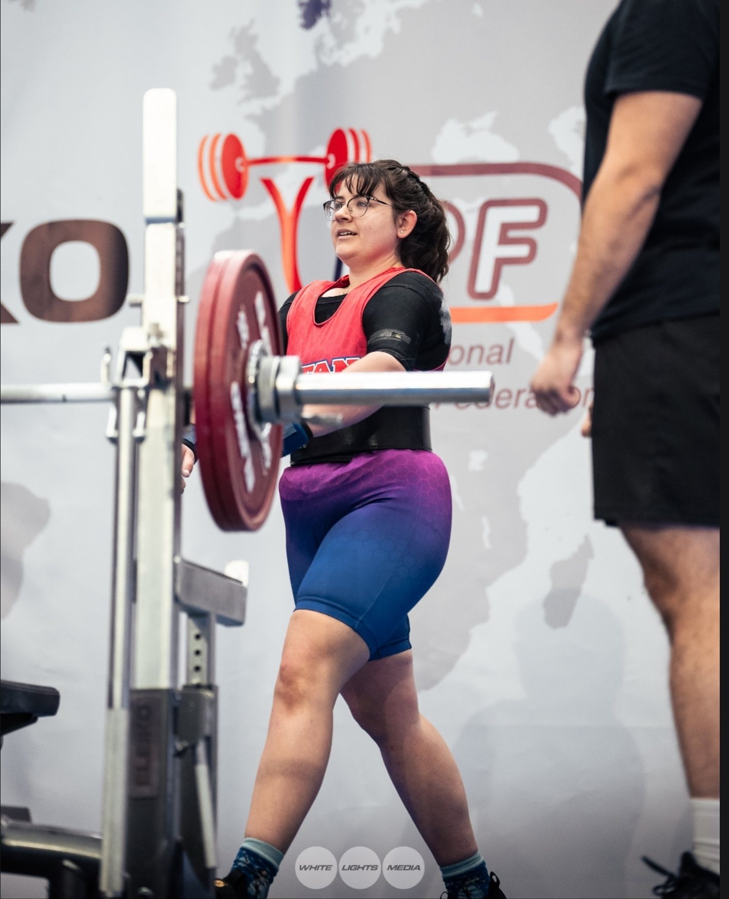 Emily walking a loaded bar out of the rack at an international powerlifting meet