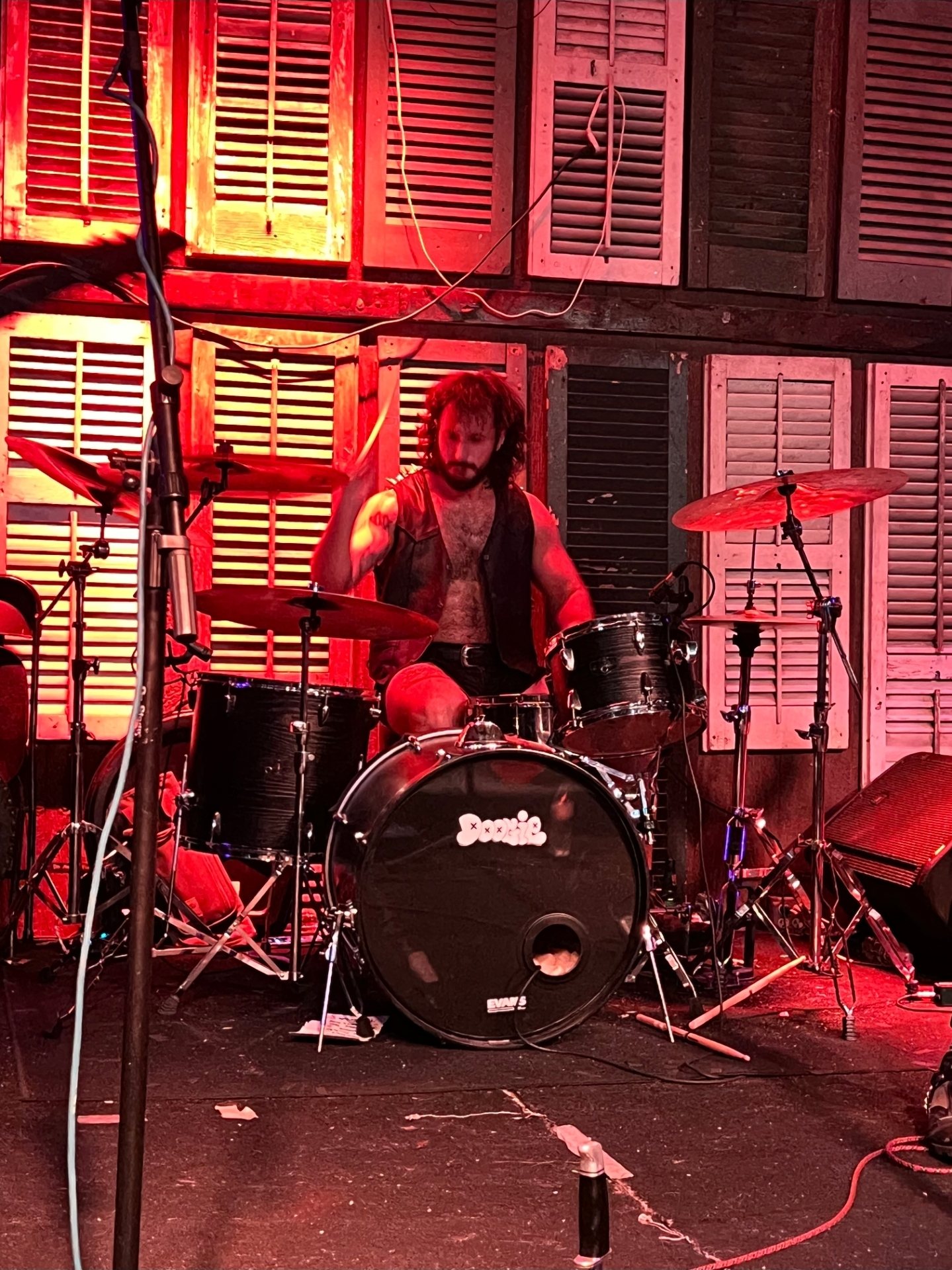 Garret behind the drum kit on stage under red lights