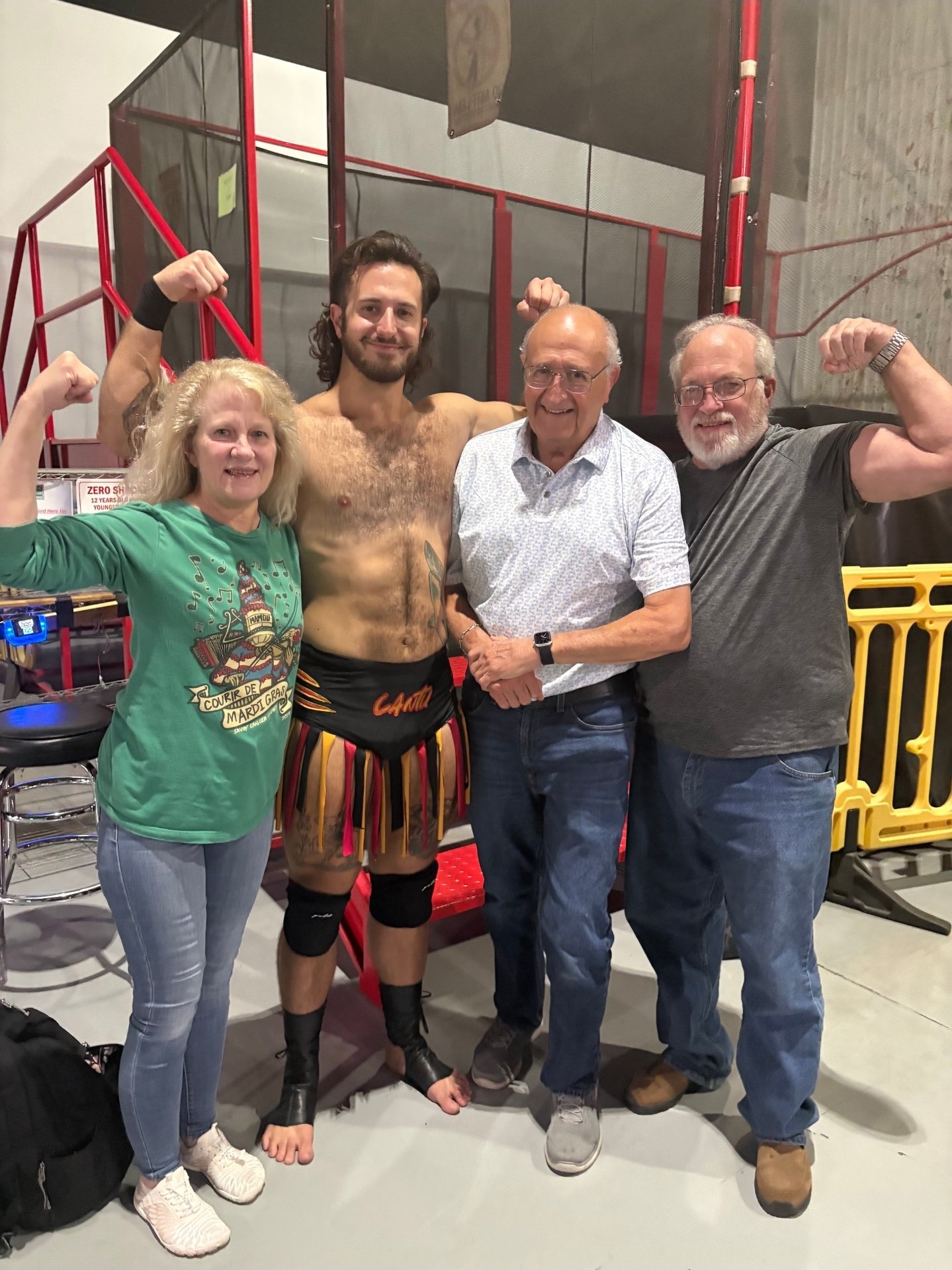 Garret in his wrestling gear, flexing with three fans after a show