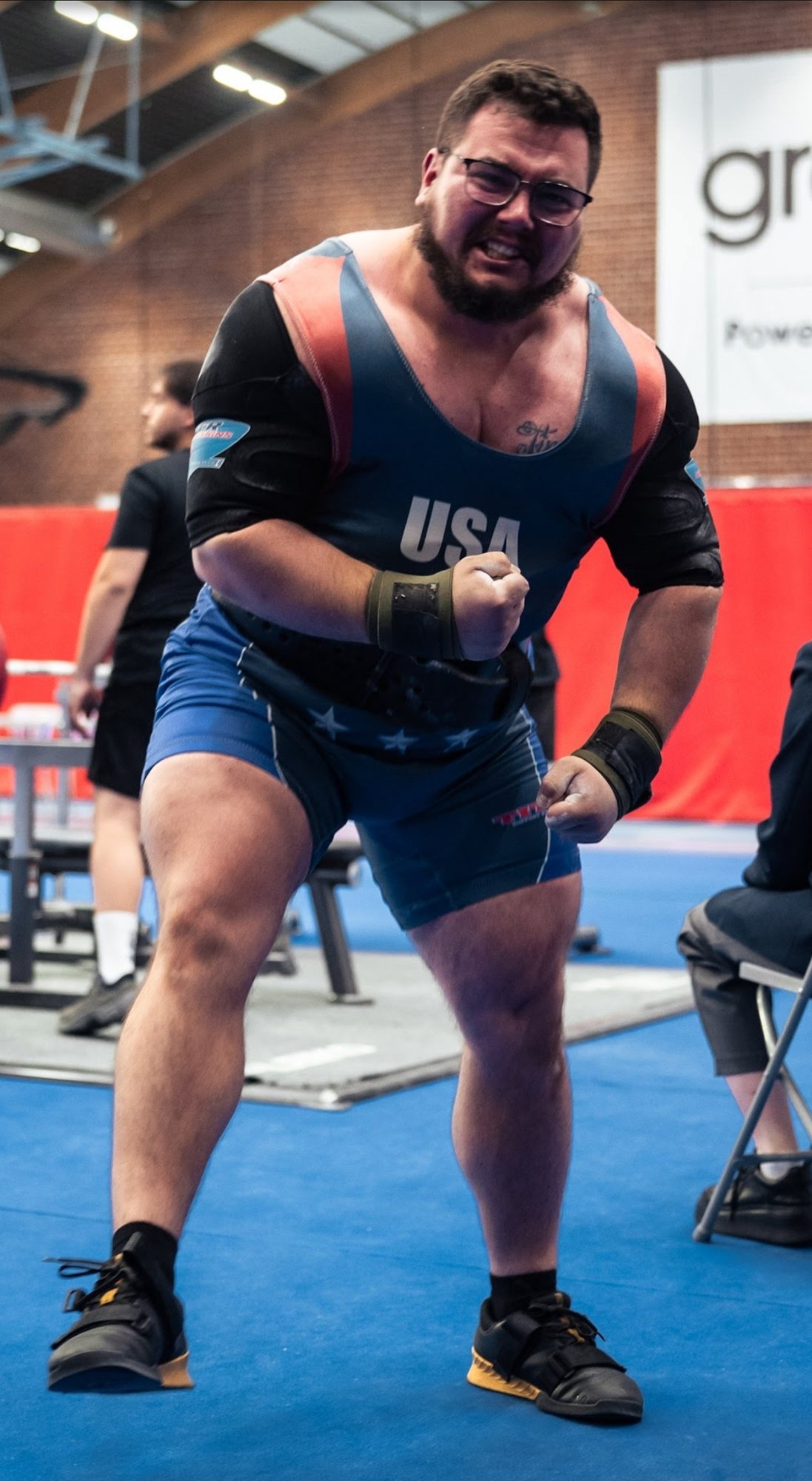 Jessie in a USA singlet, fists clenched, after a lift at an international meet