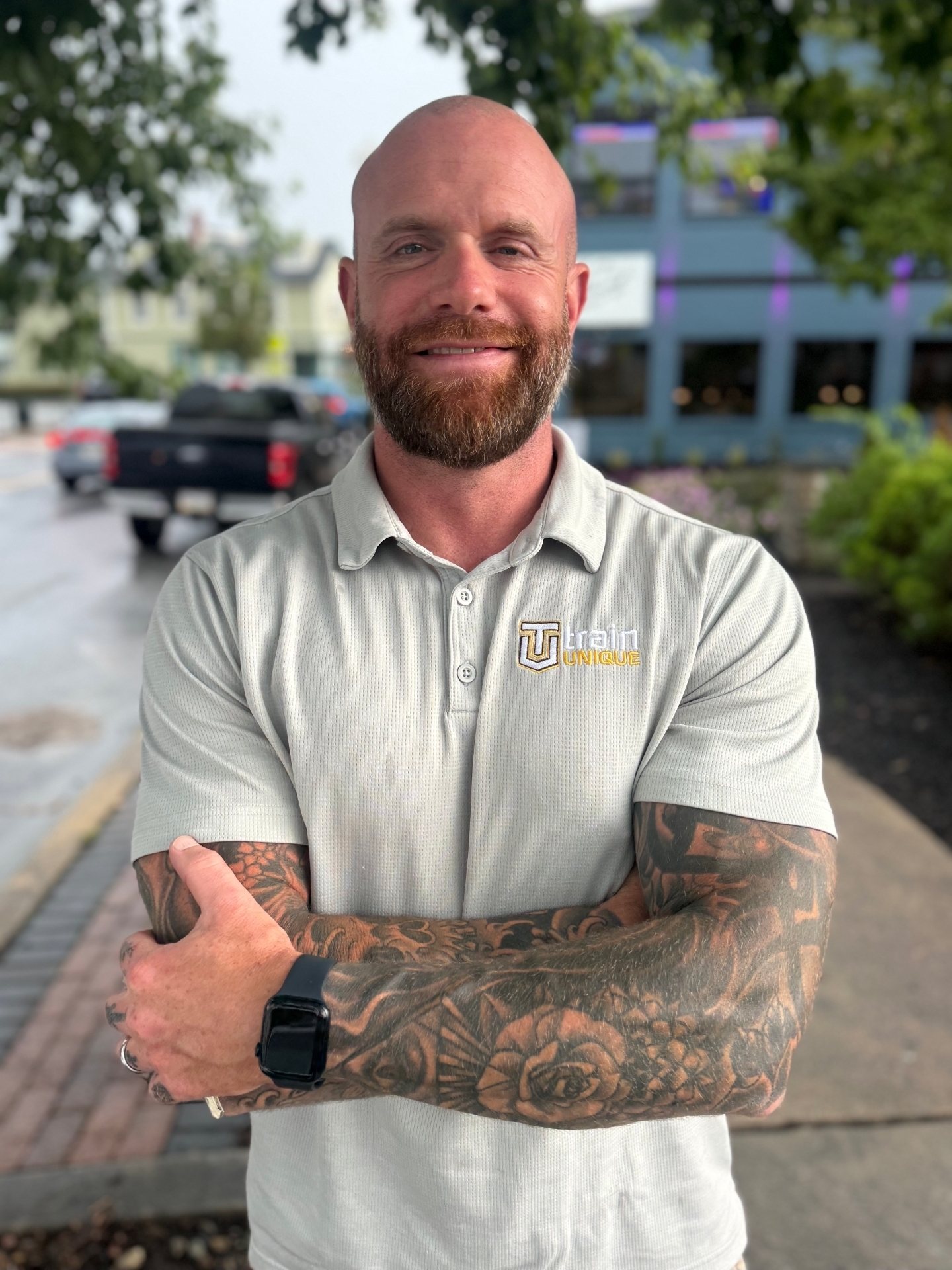 Kevin Meehan, arms crossed in a Train Unique polo