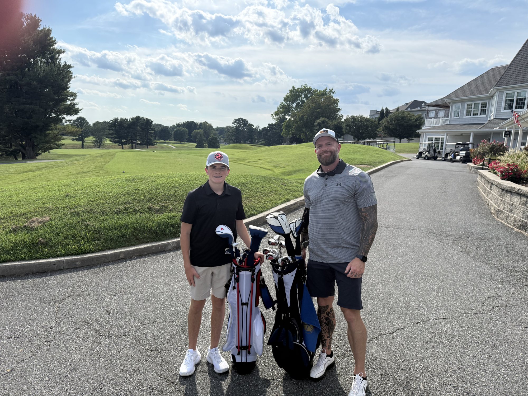 Kevin and a young golfer standing with their bags at the edge of the course