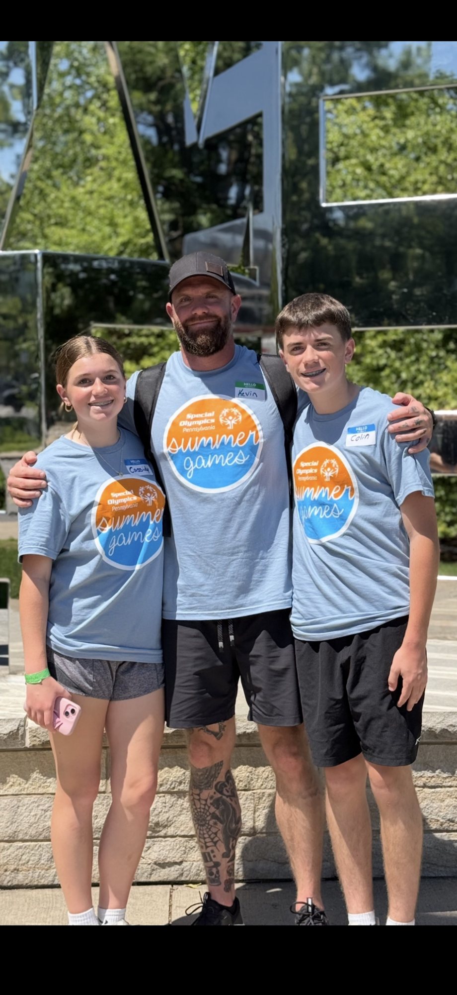 Kevin with two teens in Special Olympics Pennsylvania Summer Games shirts