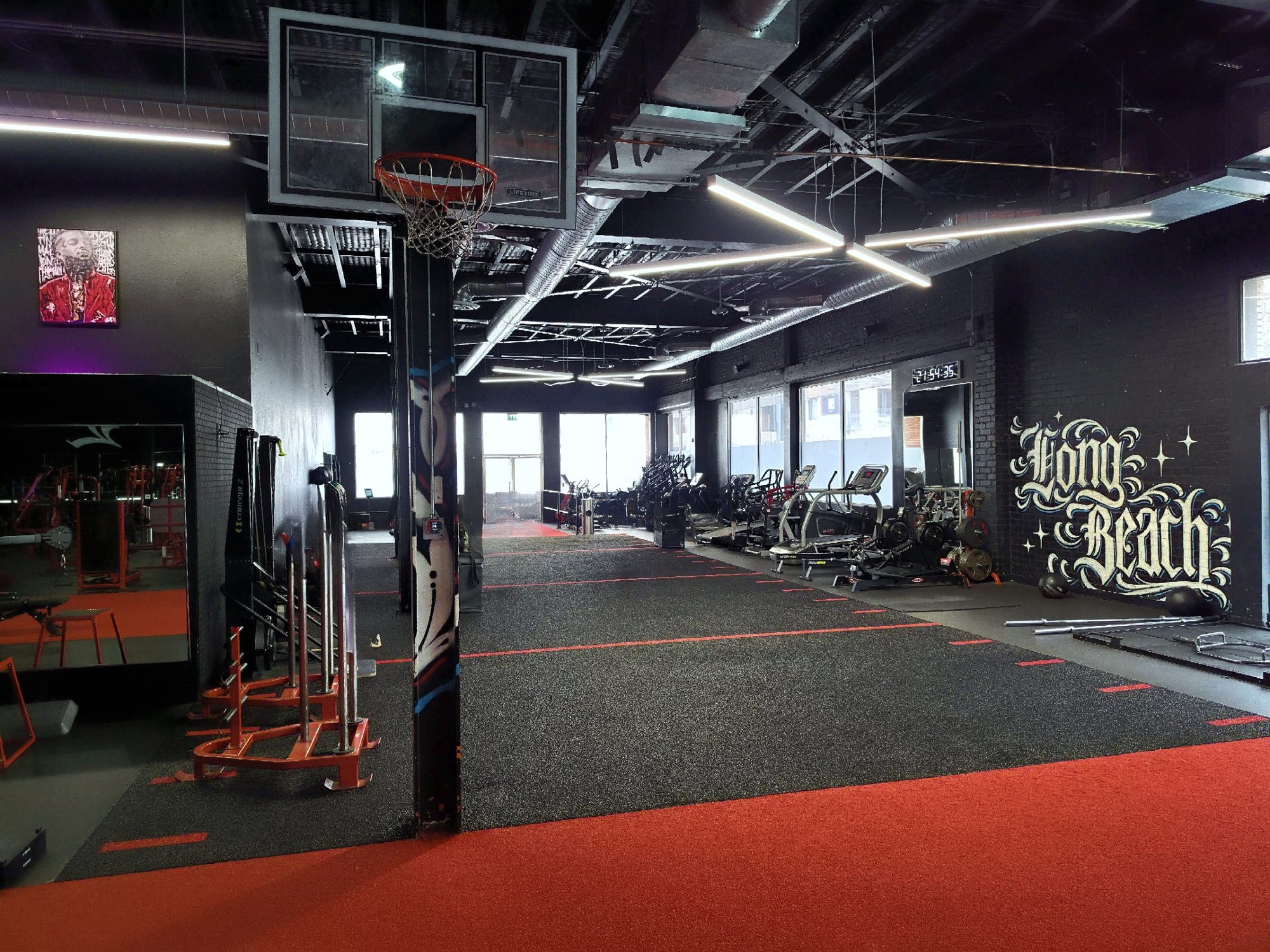 The Long Beach floor at Trinity Training Facility: turf lanes, cardio along the windows, a Long Beach mural on the wall