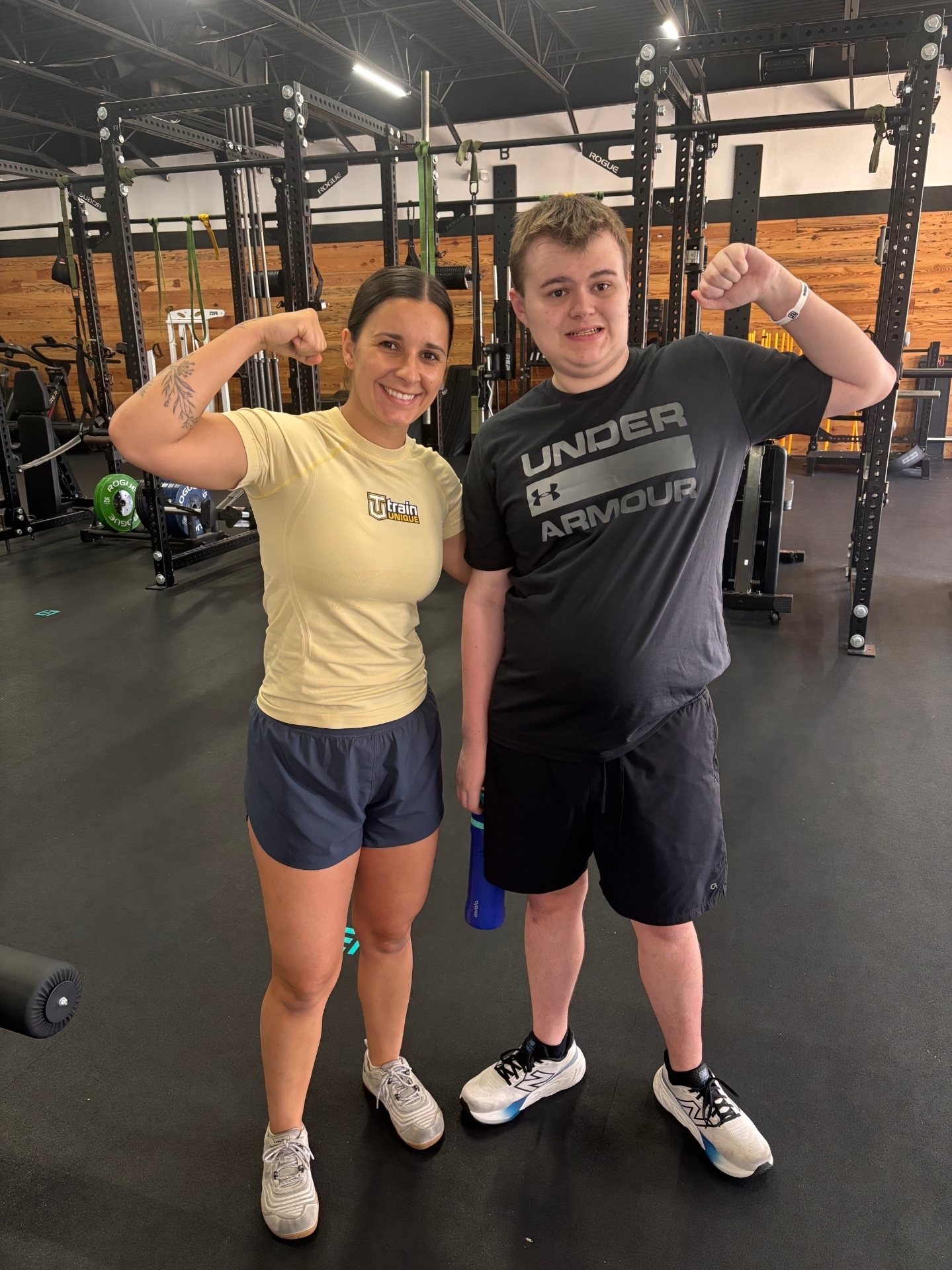 Madison and an athlete flexing together on the Baton Rouge floor