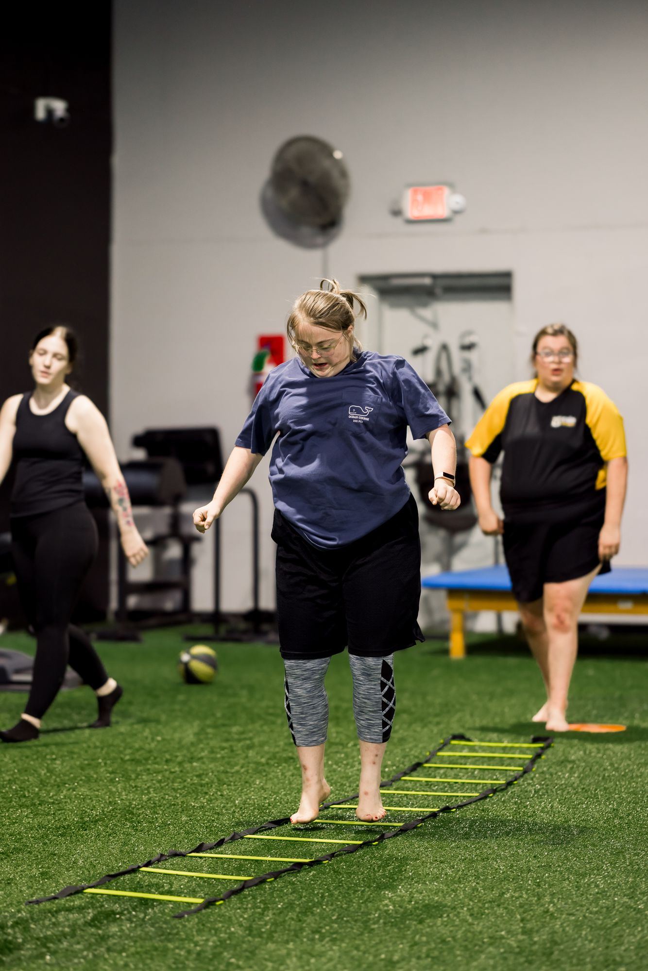 Two athletes working the agility ladder together