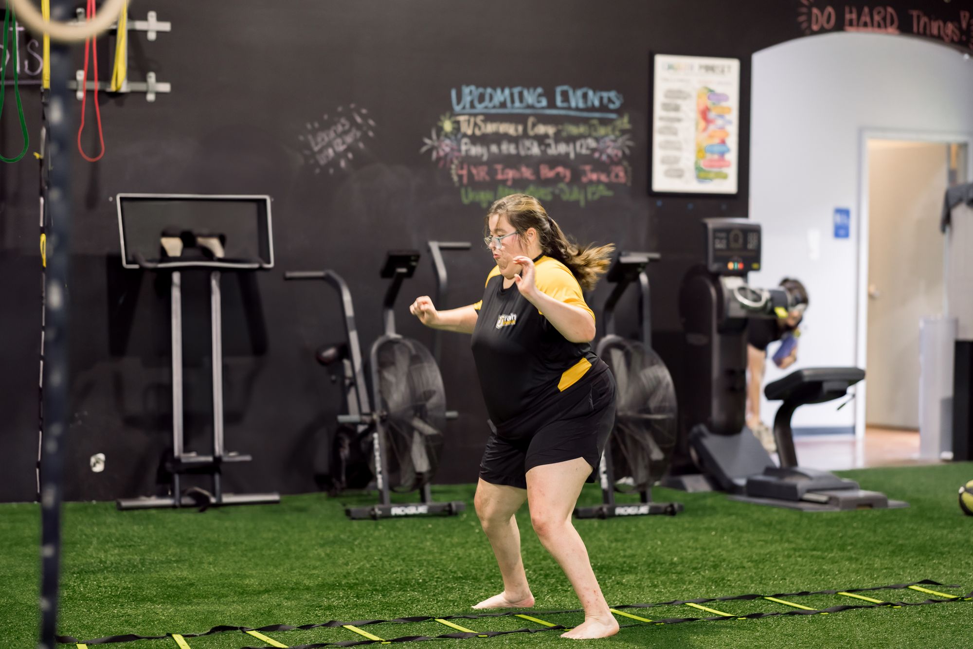 An athlete sprinting the agility ladder drill