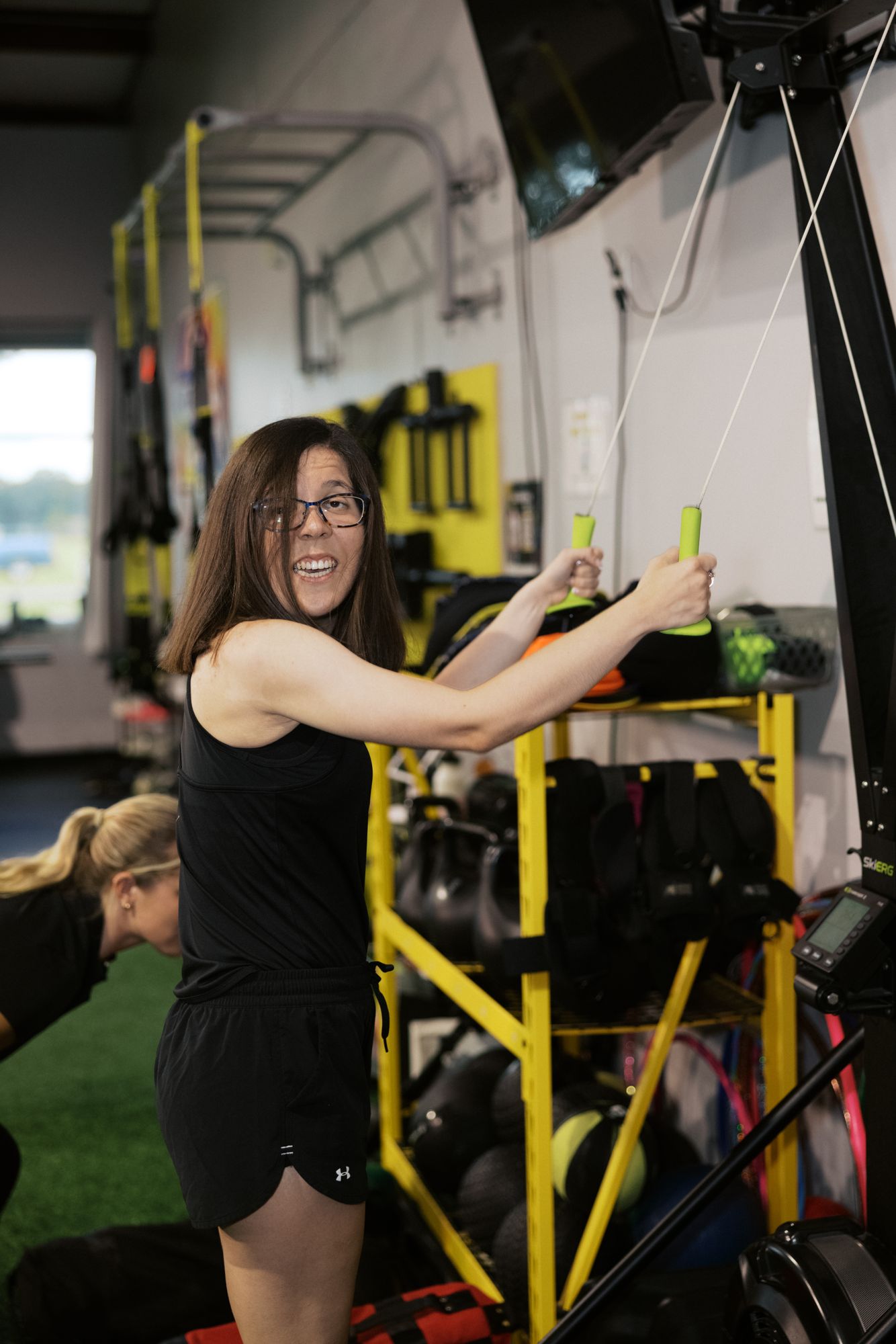 An athlete grinning through her set at the cable stack