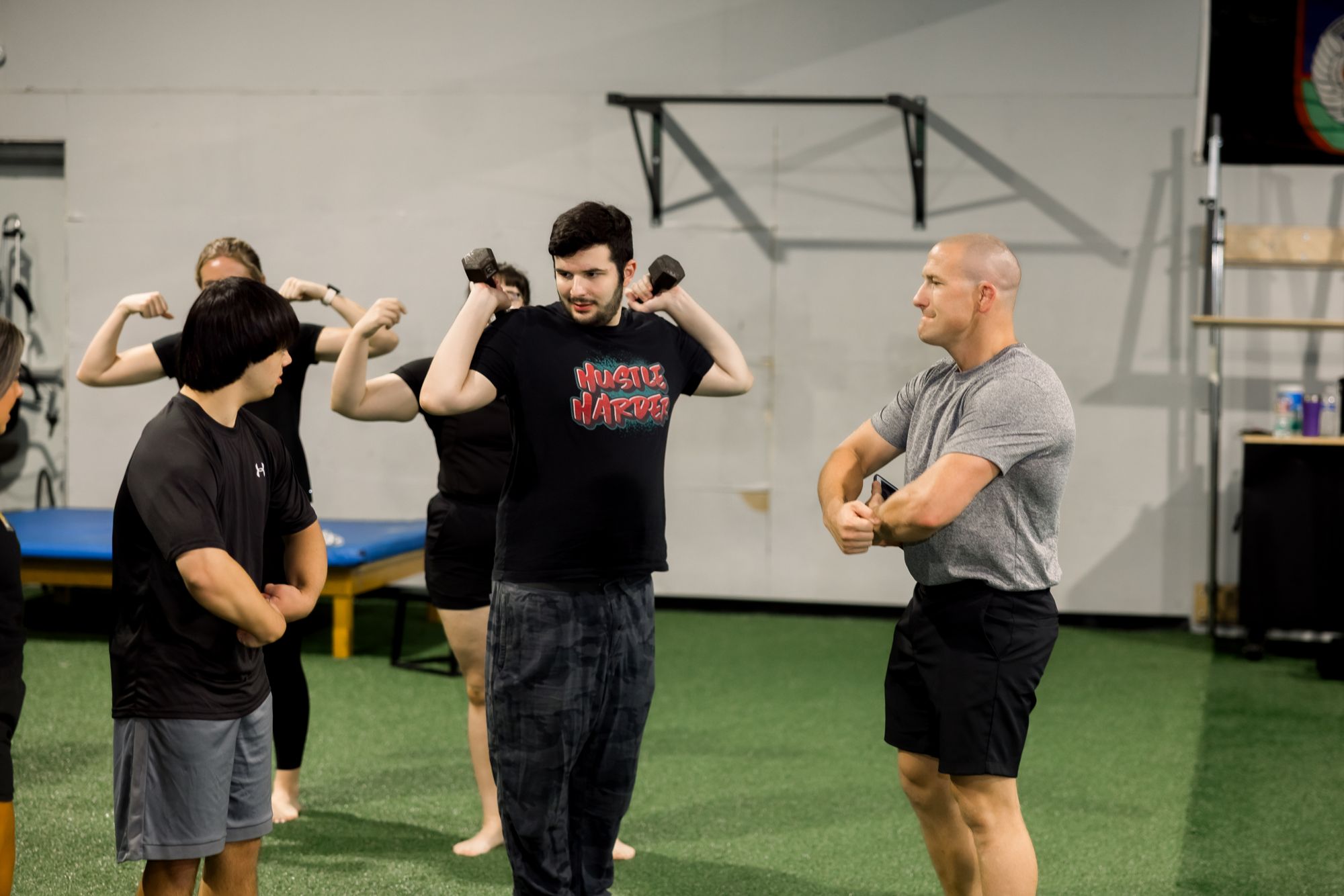 Athletes working dumbbell curls with their coaches