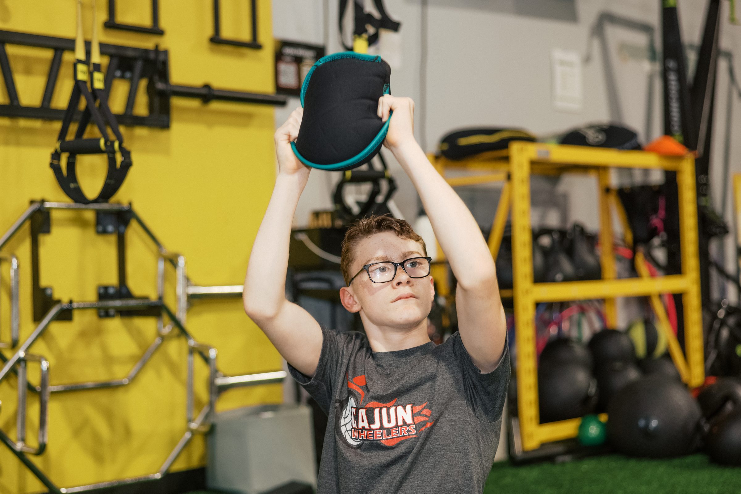 A young athlete pressing a plate overhead