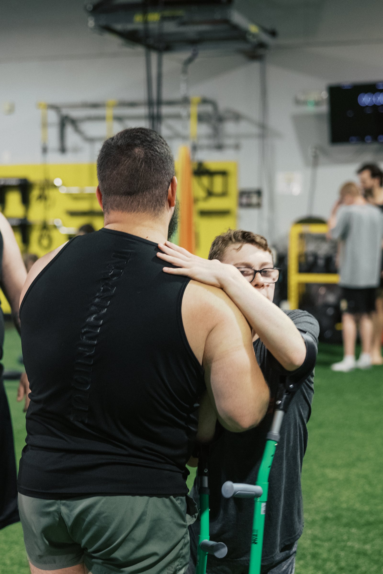 A coach and an athlete mid-hug