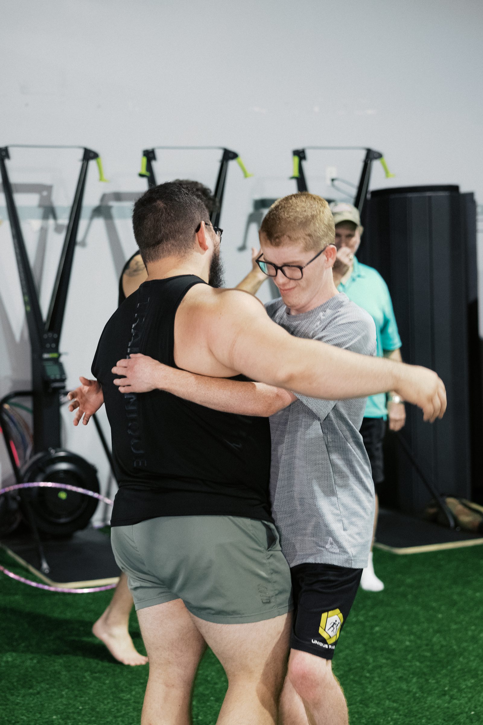 Two athletes mid-hug between sets