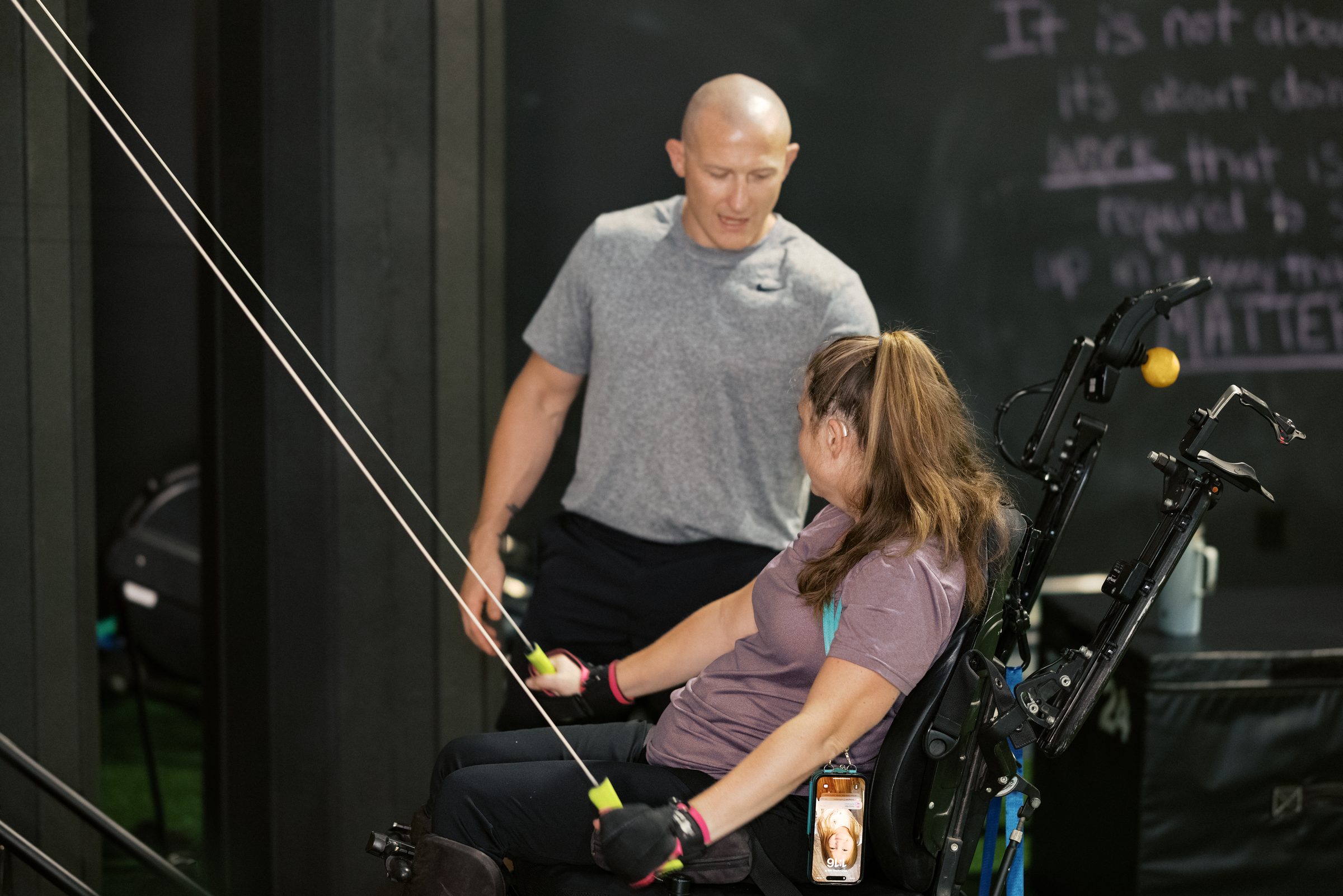 A coach working one-to-one with an athlete on the cable machine