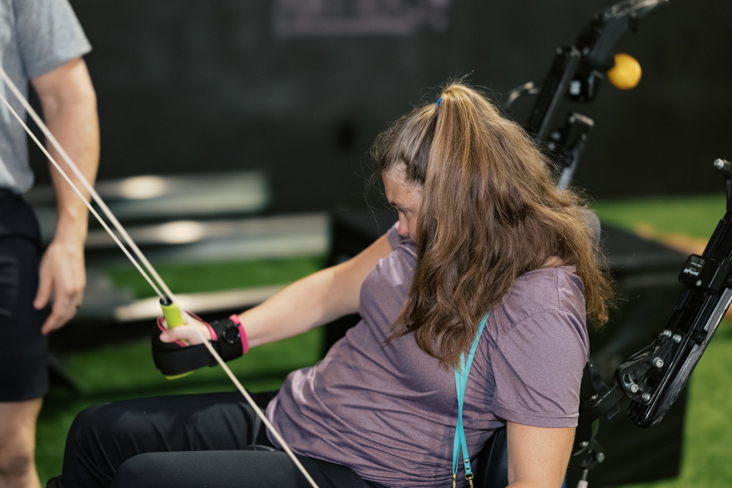 An athlete working the cable machine with her coach